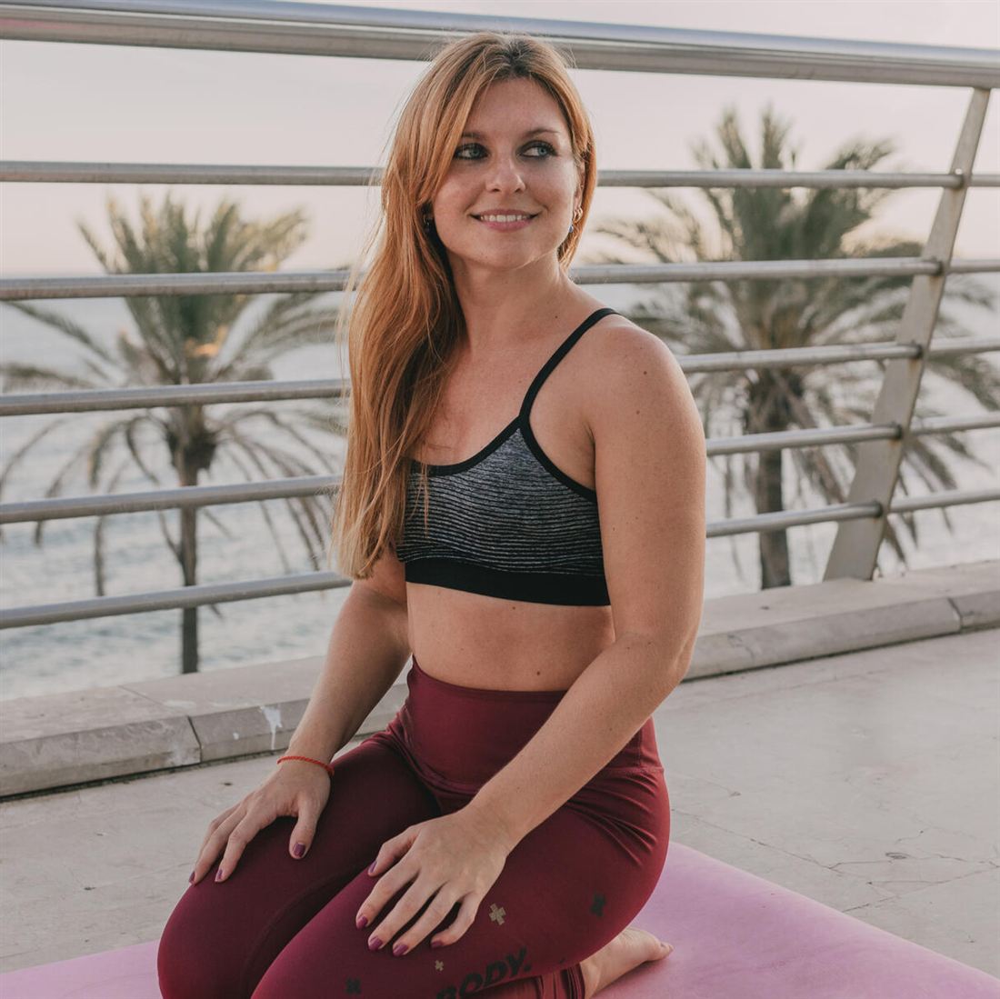 Raquel Santos sentada sobre su esterilla junto al mar
